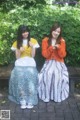 Two young women sitting on a bench in a park.