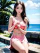 A woman in a pink bikini sitting by a pool.