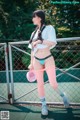 A woman in a white shirt and pink tights standing on a tennis court.