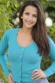 A woman in a blue cardigan posing for a picture.