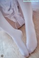 A close up of a woman's legs in white stockings.