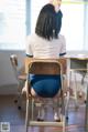 A woman sitting on a chair in a classroom.